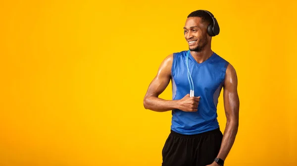 Zwarte sportman met springtouw luisteren naar muziek — Stockfoto