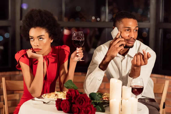 Menina entediada jantando com namorado sentado no restaurante — Fotografia de Stock