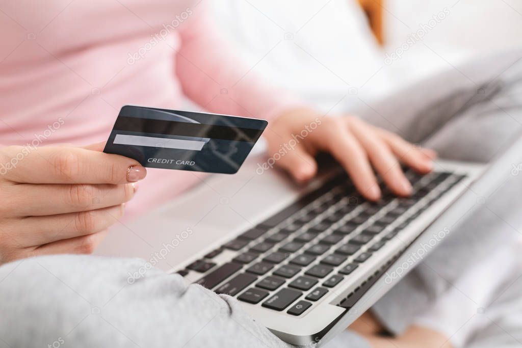 Woman checking her bank card balance on laptop