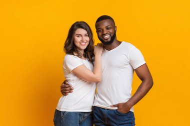 Romantik, ırklar arası bir çiftin birbirine sarılıp poz vermesinin portresi