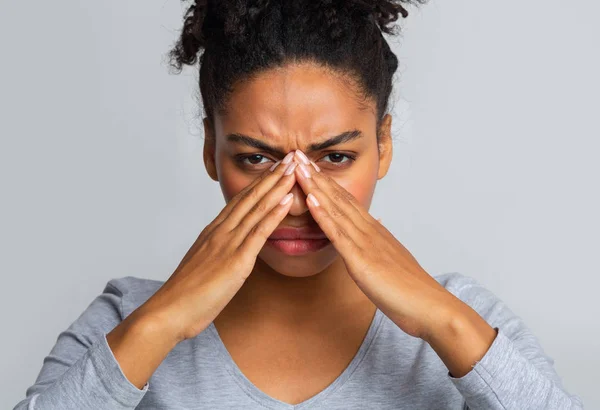 Stanco ragazza nera che soffre di antrite, strofinando ponte naso — Foto Stock