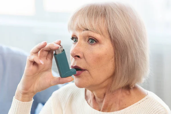 Pacjentka w podeszłym wieku stosująca inhalator astmy w leczeniu alergii — Zdjęcie stockowe