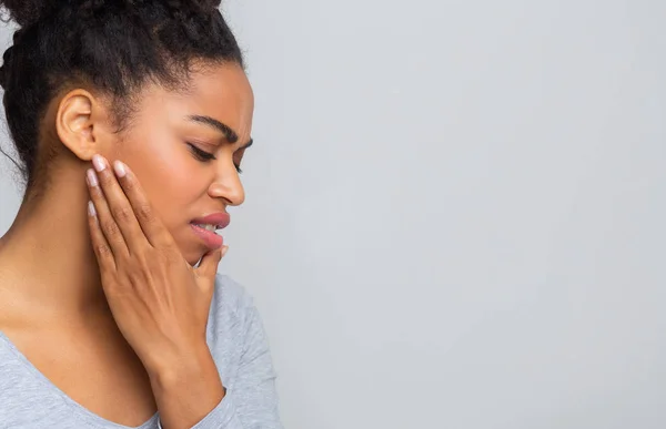 Mladá žena trpí akutní bolestí zubů, drží si čelist — Stock fotografie