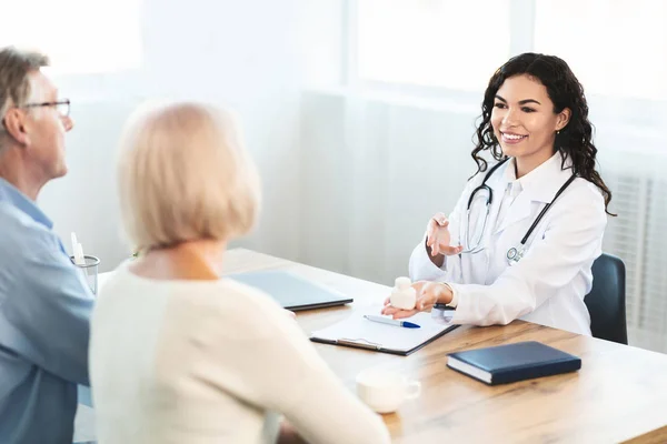 Médico hispano consultando pareja de ancianos cómo usar la píldora — Foto de Stock