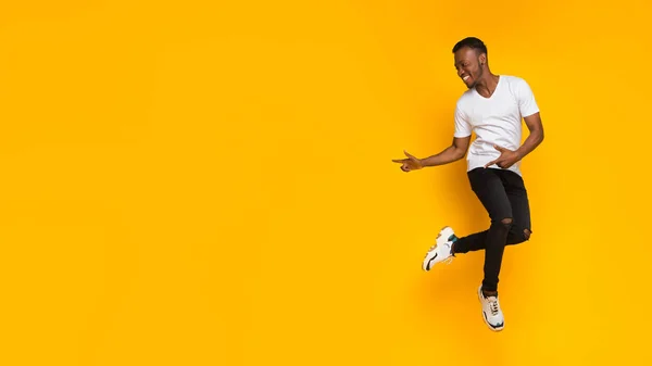 Guy apontando os dedos além de se divertir sobre fundo amarelo, Panorama — Fotografia de Stock