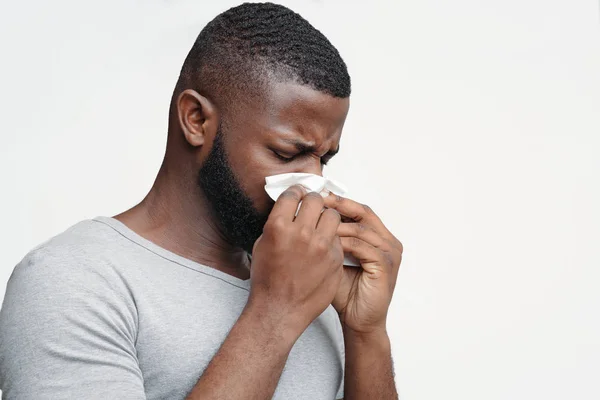 Um tipo com corrimento nasal, a tocar no nariz com guardanapo — Fotografia de Stock