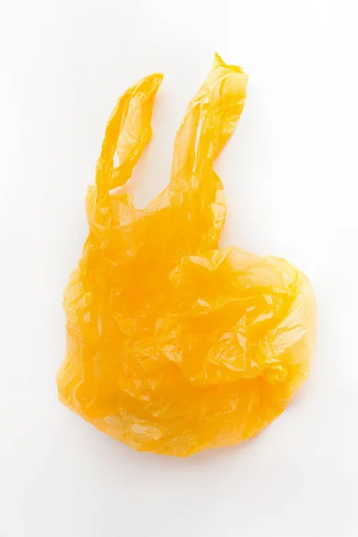 Yellow plastic shopping bag flying over white background — Stock Photo, Image