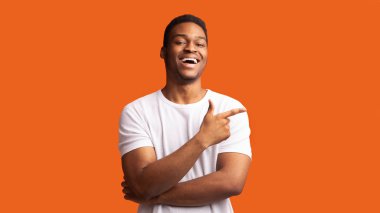 Black guy pointing aside at copy space