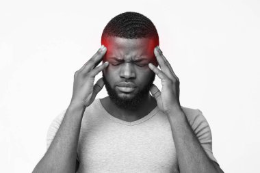 Black man suffering from headache, touching his temples