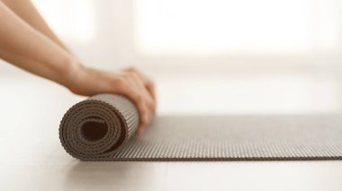 Pilates konsepti. Eğitimden sonra yoga minderi saran kadın.
