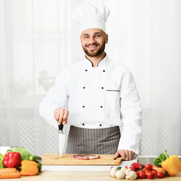 Šéfkuchař vaření masa steak držení nůž stojící v kuchyni — Stock fotografie