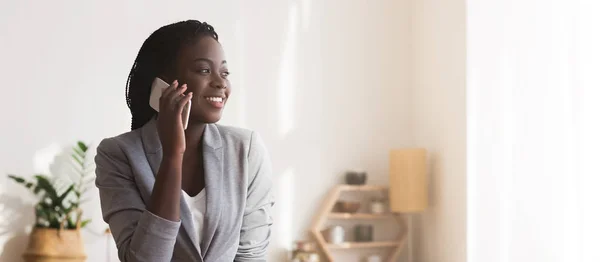 Молодая чернокожая деловая женщина разговаривает по мобильному телефону со своим партнером — стоковое фото