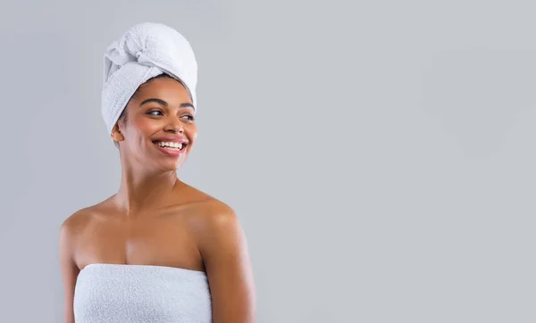 Mulher feliz envolto em toalhas olhando para o espaço de cópia — Fotografia de Stock