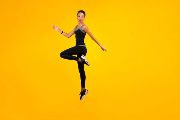 Afro-Lady springt im Studio auf gelbem Hintergrund — Stockfoto