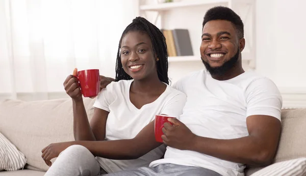 Porträt eines glücklichen Afro-Paares, das zu Hause kuschelt und Kaffee trinkt — Stockfoto