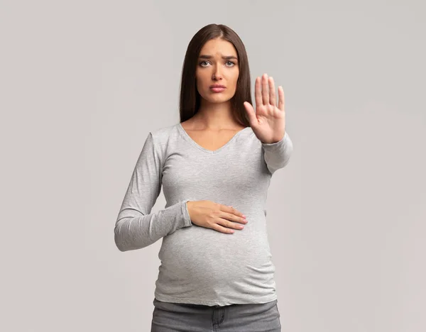 Menina grávida Gesturing Pare de pé em fundo cinza — Fotografia de Stock