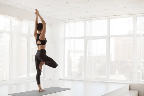 Morgonträning. Flicka gör yoga, öva träd pose — Stockfoto