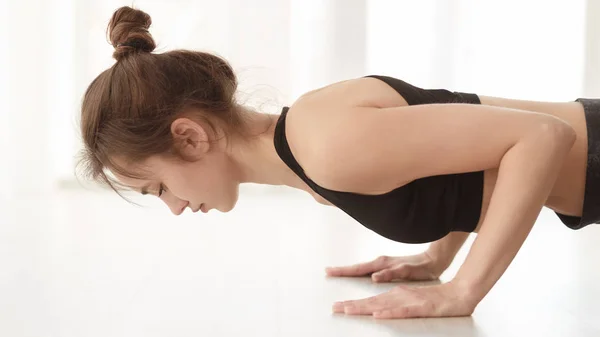 Сильне тіло. Дівчина робить йогу, стоячи на дошці — стокове фото