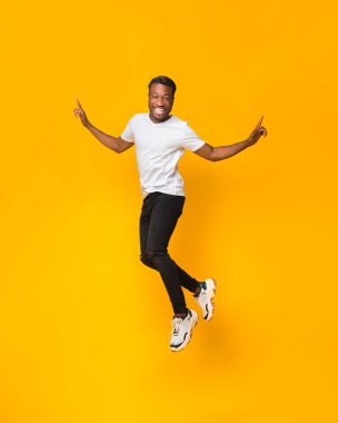 Afro Adam Sarı Arkaplanda Havada Zıplayarak Eğleniyor