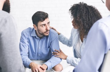 Depresyondaki adam rehabilitasyon grubunun hastalarından destek alıyor.