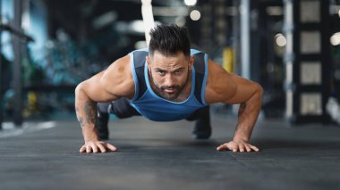 Güçlü adam kalas yapıyor ya da şınav çekiyor.