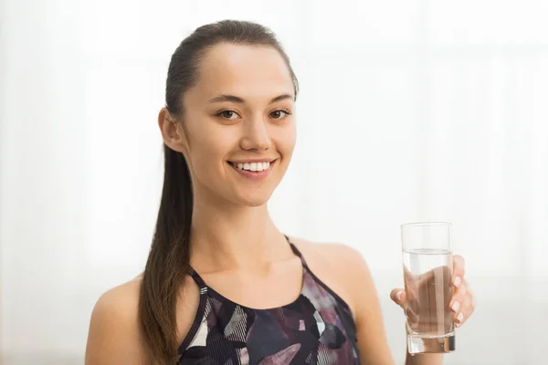 Conceptul de hidratare. Fata cu pahar de apă după antrenament acasă — Fotografie, imagine de stoc