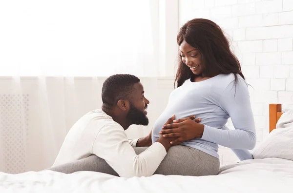 Attentive husband caressing his pregnant woman tummy — Stock Photo, Image