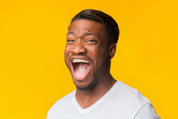 Emozionale afro uomo urlando in piedi su sfondo giallo, Studio girato — Foto Stock