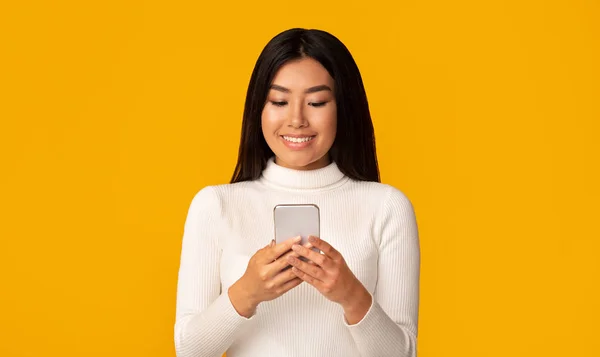 Cooles Gadget. interessiert asiatische Mädchen mit Smartphone — Stockfoto