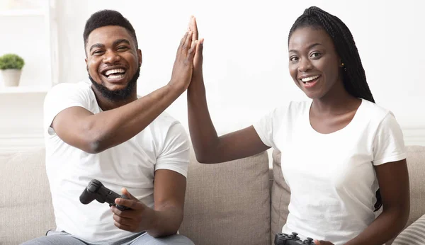 Pareja dando high-five a la otra mientras juega videojuegos — Foto de Stock