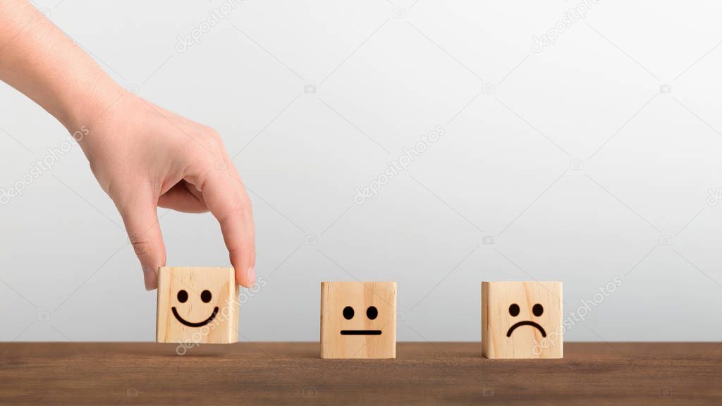 Hand picked the happy face smile symbol on wooden cube