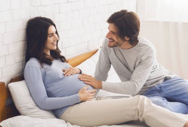 Sevgili koca, karısının karnını okşuyor.