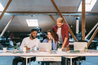 Gece geç saatlerde dizüstü bilgisayarda birlikte çalışan programcılar