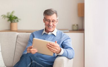 Mutlu Olgun Adam Evde Koltukta Otururken Tablet Kullanıyor