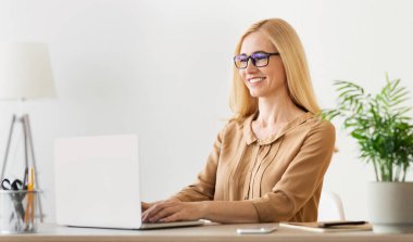 Bilgisayar çalışıyor. Olgun Freelancer dizüstü bilgisayarda geziniyor