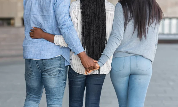 Afro kille kramas med en tjej och hålla hand med en annan — Stockfoto