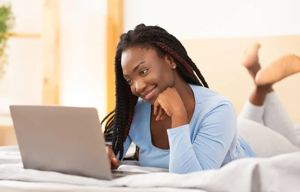 Student meisje met behulp van laptop maken van video bellen liggen in de slaapkamer — Stockfoto