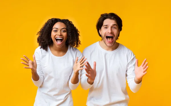 Impresionante pareja multirracial exclamando con asombro y emocionalmente gestos con las manos — Foto de Stock