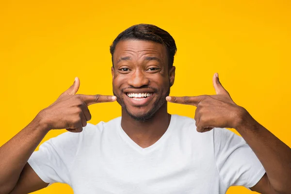 Gioioso afro uomo puntando dita al suo sorriso, Studio Shot — Foto Stock