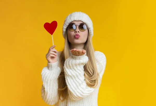 Lovely girl holding heart card and sending flying kiss — 스톡 사진