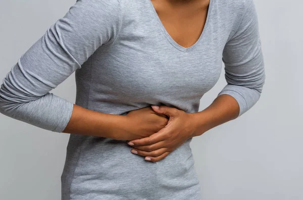 Zwarte vrouw die lijdt aan gastritis, aanraken van haar buik — Stockfoto