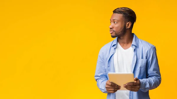 Afro Guy Holding Digital Tablet Looking Aside, Yellow Background, Panorama — 스톡 사진