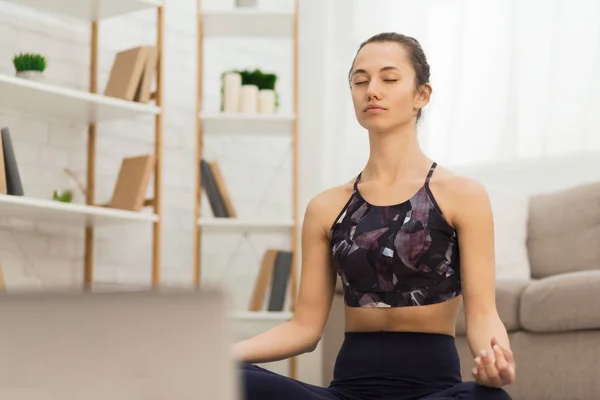 Mulher meditando com os olhos fechados, ouvindo música relaxada no laptop — Fotografia de Stock