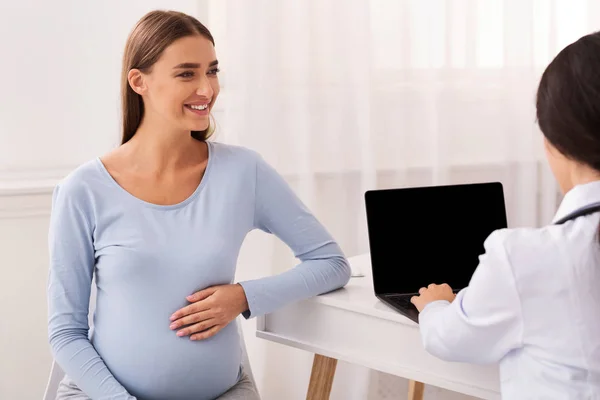 Szczęśliwa dziewczyna w ciąży Odwiedzając lekarza siedzi w biurze — Zdjęcie stockowe