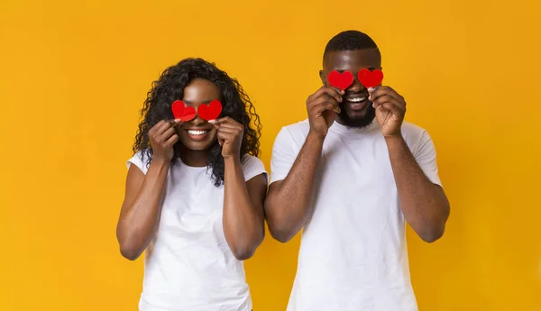 Pareja negra cerrando los ojos con tarjetas rojas de San Valentín — Foto de Stock