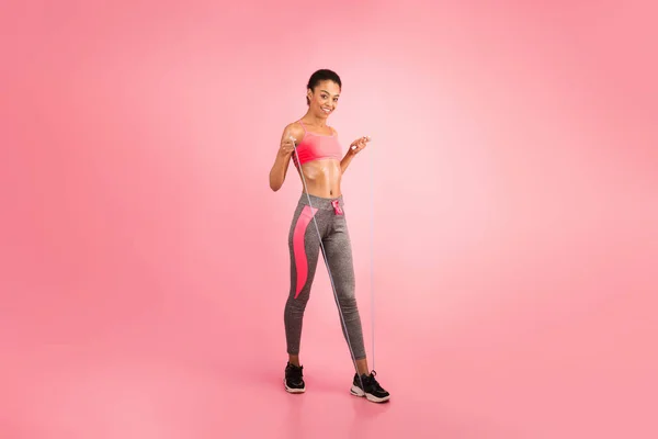 Afro Woman with Jump Rope Smiling At Camera, Pink Background — стокове фото