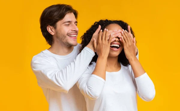 Loving guy verrassen zijn vriendin, bedekken haar ogen met handen — Stockfoto