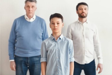 Babam ve büyükbabam arasında duran çocuk Beyaz Duvar 'a karşı