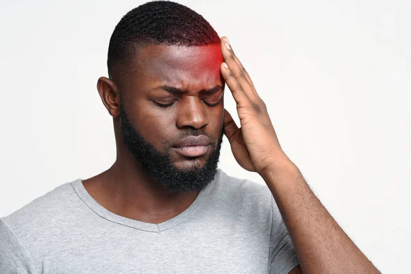 Ung man som lider av huvudvärk, berörande panna — Stockfoto