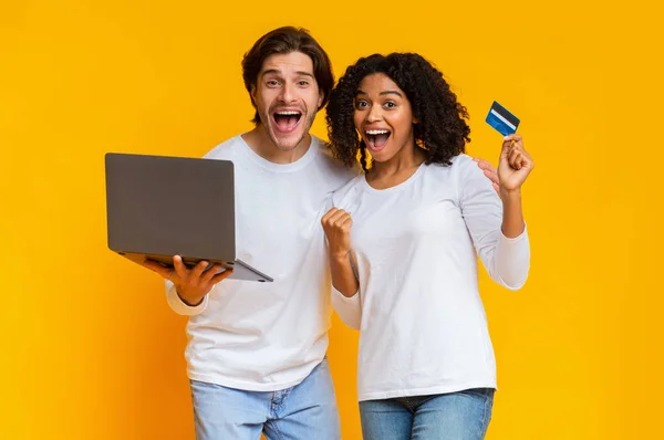 Overjoyed coppia multirazziale shopping online con laptop e carta di credito — Foto Stock